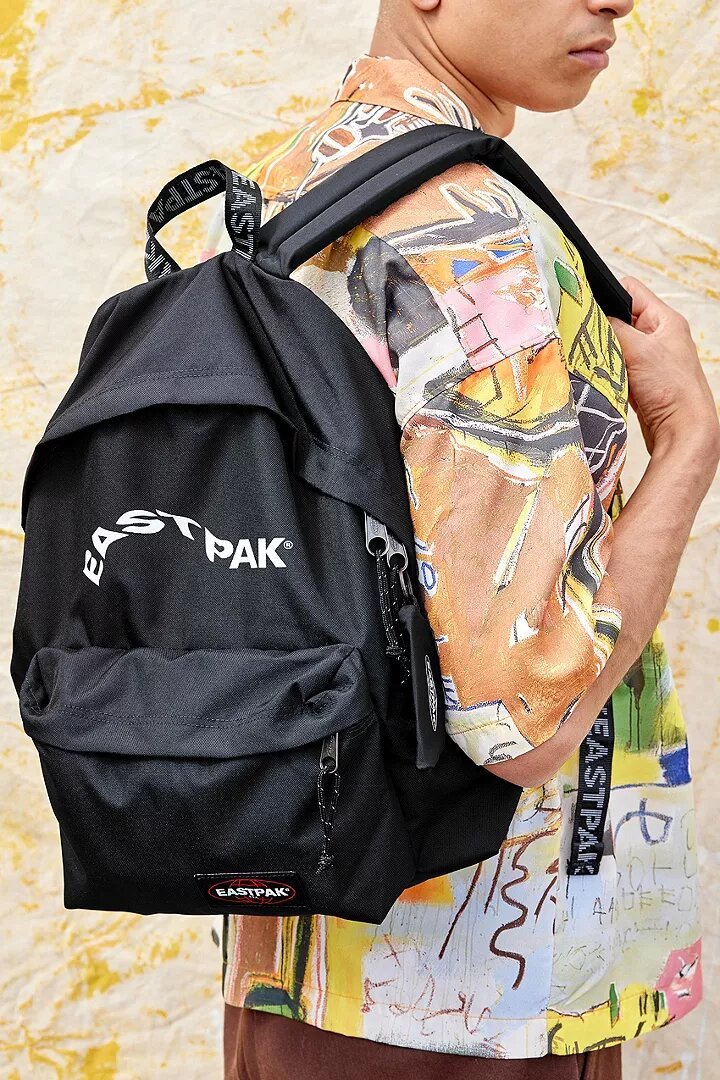 Ein Mann, der einen der schwarzen Rucksäcke von Eastpak trägt