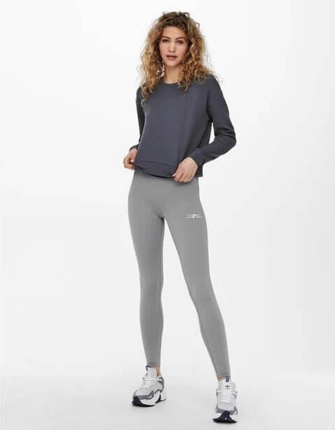 Wunderschöne Frau trägt ein Sweatshirt und graue Leggings