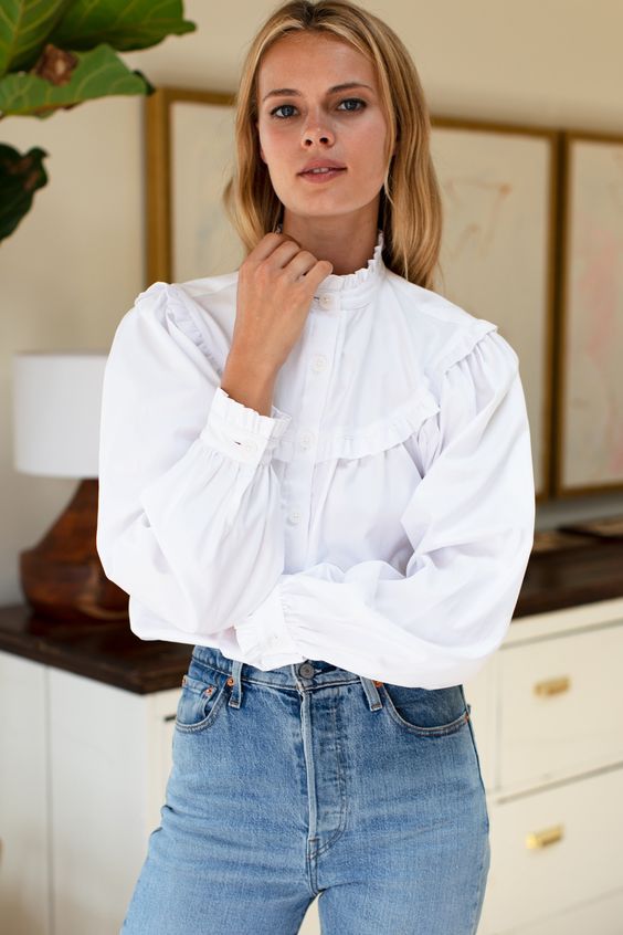 Eine Frau mit einem weißen Hemd-Bodysuit und einer Jeans