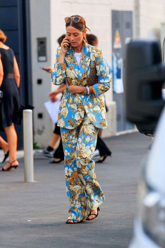 Frau, die einen Anzug mit floralen Mustern im totalen Look trägt