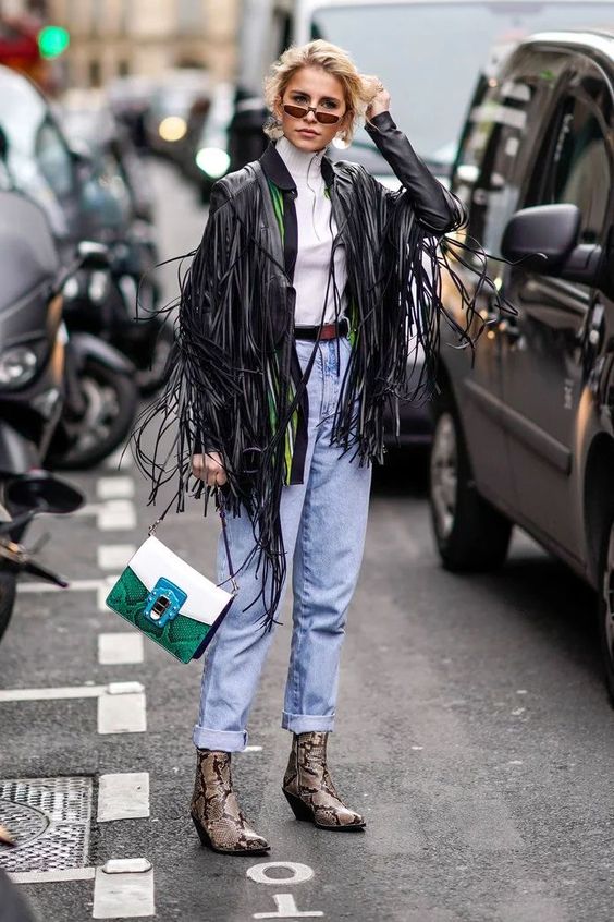 Frau auf der Straße in einem Frühlingslook mit einer Fransenjacke