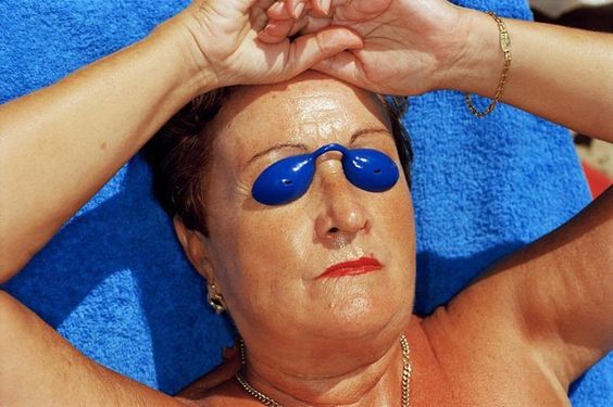 Foto von Martin Parr Frau, die mit Augenbinde bräunt